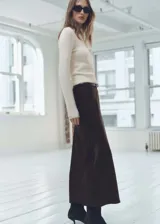 Jersey blanco de tejido de punto, con cuello alto envolvente y diseño recto de manga larga.