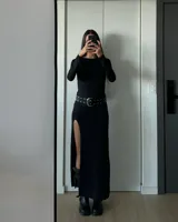 Vestido largo negro de lycra, con escote redondo, mangas largas y tajo alto en la pierna.