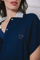 Camisa maternal gris claro de viscosa suave, con cuello camisero azul marino, cierre frontal con botones, mangas cortas y bolsillo lateral.