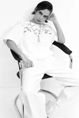 Remera blanca de algodón con cuello redondo y mangas cortas. Presenta un diseño calado en el frente.