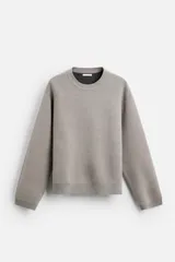 Jersey color gris topo de punto, con cuello redondo y manga larga.