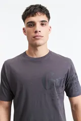Remera gris de manga corta con cuello redondo y estampado tipográfico en el frente.