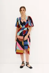 Vestido midi de gasa estampada con diseño geométrico multicolor, mangas cortas y elástico en la cintura. Tiene tajo frontal y forro en la falda.