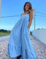 Maxi vestido celeste de jean con breteles regulables y bolsillos laterales.