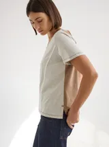 Remera gris de manga corta con cuello redondo y líneas verticales en blanco y negro. Corte recto y holgado. Confeccionada en algodón y spandex.