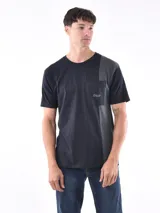 Remera negra con bolsillo en el pecho y diseño geométrico en gris en el hombro y lateral.