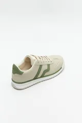 Zapatillas beige con recortes en gamuza de diferentes tonos, cordones y suela irregular blanca con detalle rosa.