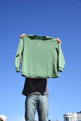 Buzo verde con cuello redondo y logo bordado en el pecho.