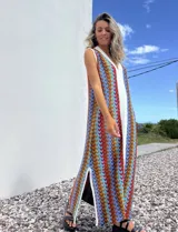 Vestido largo de tejido con diseño geométrico en tonos celeste, marrón, rojo y blanco. Tiene escote en V y aberturas laterales.