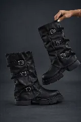 Bota biker negra de caña media, estilo polaina, con efecto arrugado y tres correas ajustables con hebillas metálicas cuadradas. Suela track gruesa y plana.