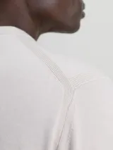 Sweater color beige de Calvin Klein, confeccionado en mezcla de tencel con elasticidad añadida. Tiene cuello redondo, puños y bajo de canalé, y etiqueta con logo de Calvin Klein por encima del bajo.