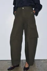 Pantalón cargo de tiro medio color verde militar, confeccionado en algodón. Presenta bolsillos delanteros y bolsillos de plastrón con solapa en las piernas.