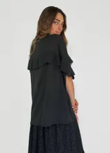 Camisa color amarillo con cuello clásico, cierre frontal con botones y mangas cortas con volados.