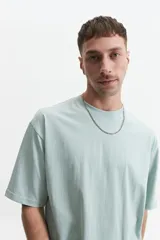 Remera de manga corta color marrón claro, de corte amplio y cuello redondo.
