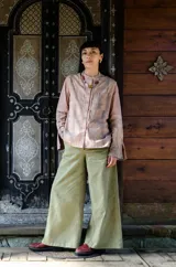 Pantalón de algodón color durazno, de silueta amplia y tiro alto, con diseño de triángulo en los laterales y cierre frontal con botones visibles.