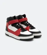 Championes de caña alta, color blanco, rojo y negro, con ajuste de cordones y velcro. Suela bicolor y puntera redondeada.