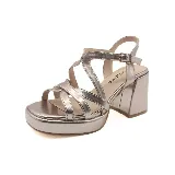 Sandalias blancas de cuero sintético con plataforma y tacón cuadrado. Diseño con tiras cruzadas y hebilla ajustable en el tobillo.