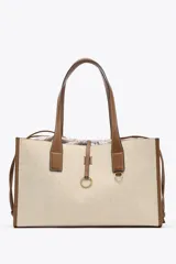 Bolso maxi shopper de hombro color beige con detalles en cuero marrón. Tiene doble asa de cuero y bolsa de tela extraíble con cierre fruncido.