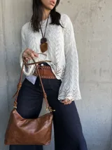 Sweater de hilo color natural con mangas acampanadas y calado en el tejido.