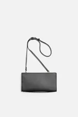 Bandolera negra rectangular con textura grabada. Tiene un compartimento principal con cierre de cremallera, un bolsillo interior con cremallera y un bolsillo simple. El asa de hombro es ajustable y extraíble.