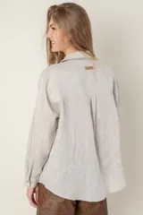 Camisa de lino color gris claro con bordado de monograma PEC en el bolsillo.