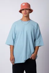 Remera verde militar de corte oversize, confeccionada en algodón 100% con cuello redondo y manga corta. Presenta un pequeño logo estampado en la parte superior de la espalda.