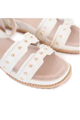Sandalias blancas de cuero con plataforma corrida forrada de 2,5 cm de altura, pulsera ajustable en el tobillo y tachas doradas decorativas.