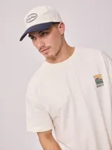 Gorra de lona lavada color azul con visera curva y parche bordado con el logo de Rusty en el frente.