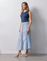 Falda midi a rayas verticales celestes y blancas, con pretina ancha elastizada en punto smock y volados en los cortes.