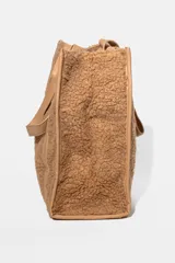 Bolso tipo tote bag color verde oliva, con textura de peluche y detalles en cuero sintético.