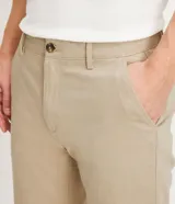 Pantalón de vestir azul marino, de corte recto, con bolsillos laterales y traseros. Se ajusta a la cintura con cinturón de cuero marrón.