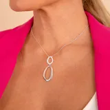 Conjunto de plata 925 con circonias, compuesto por aros colgantes ovalados y collar con dije doble ovalado.