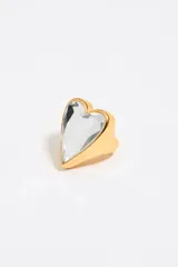 Anillo dorado con un cristal facetado transparente en forma de corazón.