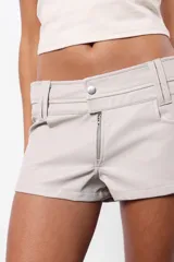 Short negro de cuerina, tiro bajo con doble cintura y cierre frontal con cremallera metálica YKK.