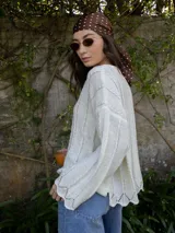 Sweater de tejido de punto color crudo con lurex dorado, escote redondo y mangas largas.