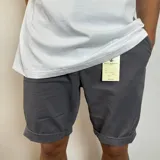Bermuda gris oscuro de gabardina, con bolsillos laterales y traseros.