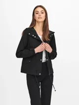 Chaqueta corta negra con capucha, mangas largas, cierre de botones, bolsillos frontales y cordón ajustable en la cintura.