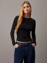 Remera negra de punto modal elástico, con cuello redondo, mangas largas y detalle plisado en un lateral.