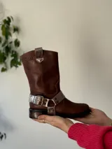 Bota de cuero marrón con estribo desmontable plateado.