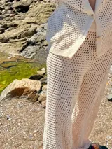 Conjunto de pantalón y cárdigan color manteca de tejido calado.