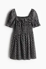 Vestido corto de crepé de algodón con estampado floral en blanco y negro, escote cuadrado con volantes, mangas cortas abullonadas con elástico en los puños, cuerpo ajustado con elástico y falda con vuelo.