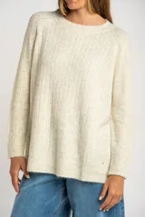 Sweater color beige de tejido texturado, con cuello redondo y mangas largas.