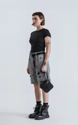 Bermuda gris con cinturón negro, bolsillos laterales y corte a la rodilla.