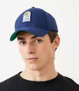 Gorra azul marino de algodón con visera curva y cierre snapback. Presenta un parche bordado con el personaje Zé Carioca.