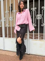 Camisa rosada de mangas largas con detalles de encaje en el frente.