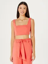 Top corto de tirantes anchos, color rosa pálido, con escote cuadrado.