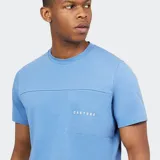 Remera deportiva de manga corta, color azul claro, con cuello redondo y un bolsillo abierto en el pecho. Presenta una costura horizontal que cruza el pecho y el logo de la marca en el frente.