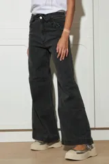 Pantalón de jean azul oscuro de pierna ancha con detalle de trenzado en bolsillos y cinturón.
