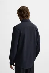Camisa azul marino slim fit de manga larga con cuello italiano abierto y cierre frontal con botones.