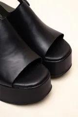 Sandalias con plataforma color marrón, con capellada envolvente, pulsera trasera ajustable y hebilla metálica.